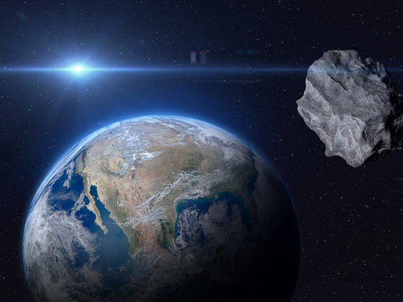 Planet Earth and big asteroid in the space. Potentially hazardous asteroids (PHAs). Asteroid in oute...