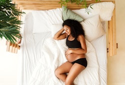 pregnant woman sleeping in bed, can sleeping positions turn breech baby