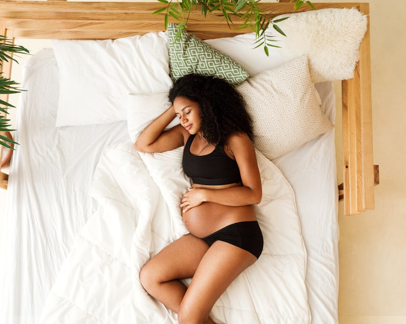 pregnant woman sleeping in bed, can sleeping positions turn breech baby