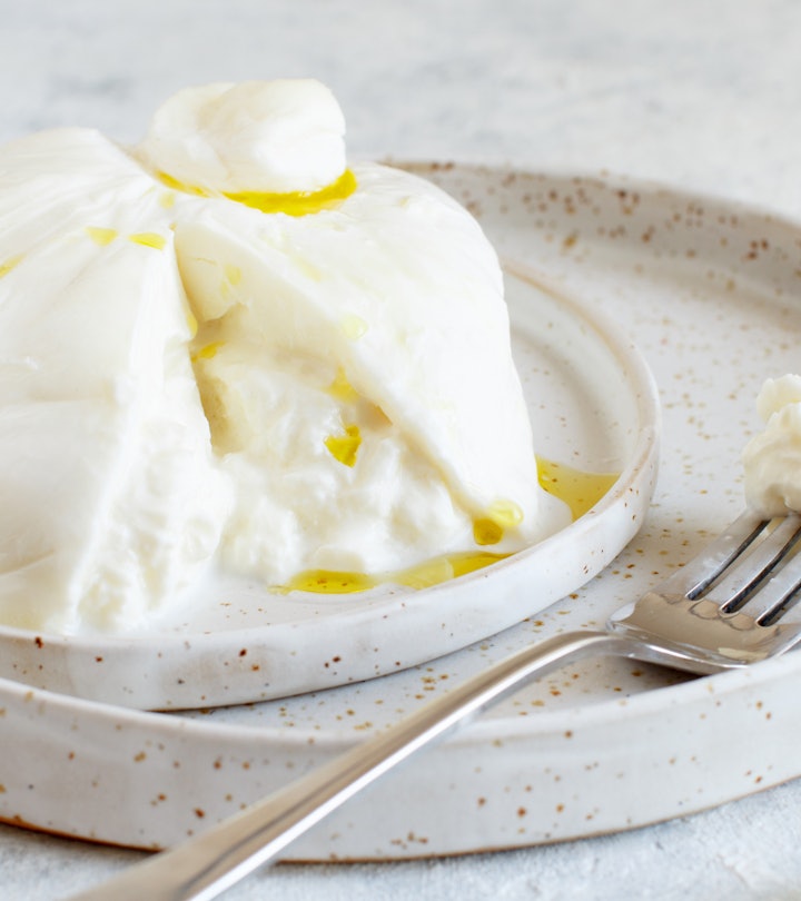 Italian burrata cheese on a plate with a fork and basil, is burrata safe to eat during pregnancy