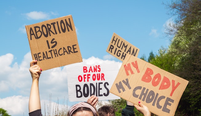 Protesters holding signs Abortion Is Healthcare, My Body My Choice, Bans Off Our Bodies, Human right...