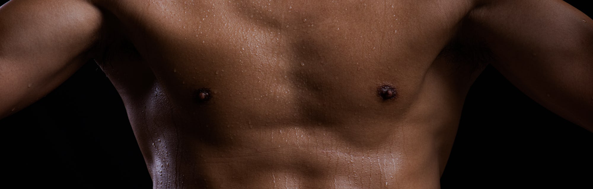 Sweat. Closeup of a strength fitness body with sweat. Fit young man with beautiful torso. Bodybuilde...