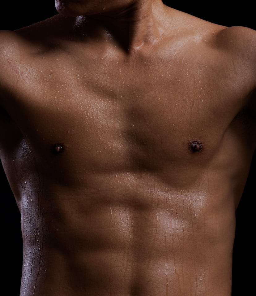Sweat. Closeup of a strength fitness body with sweat. Fit young man with beautiful torso. Bodybuilde...
