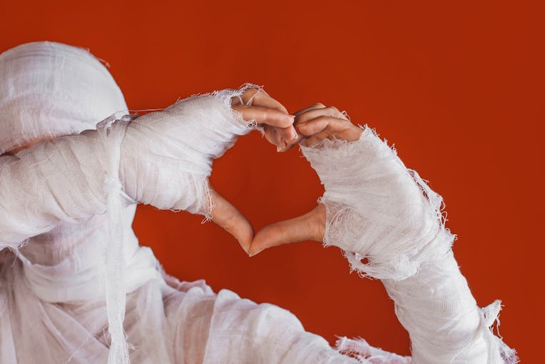 Halloween, costume image. The mummy's hand in bandages making gestures. Love you, sweet mummy shows ...