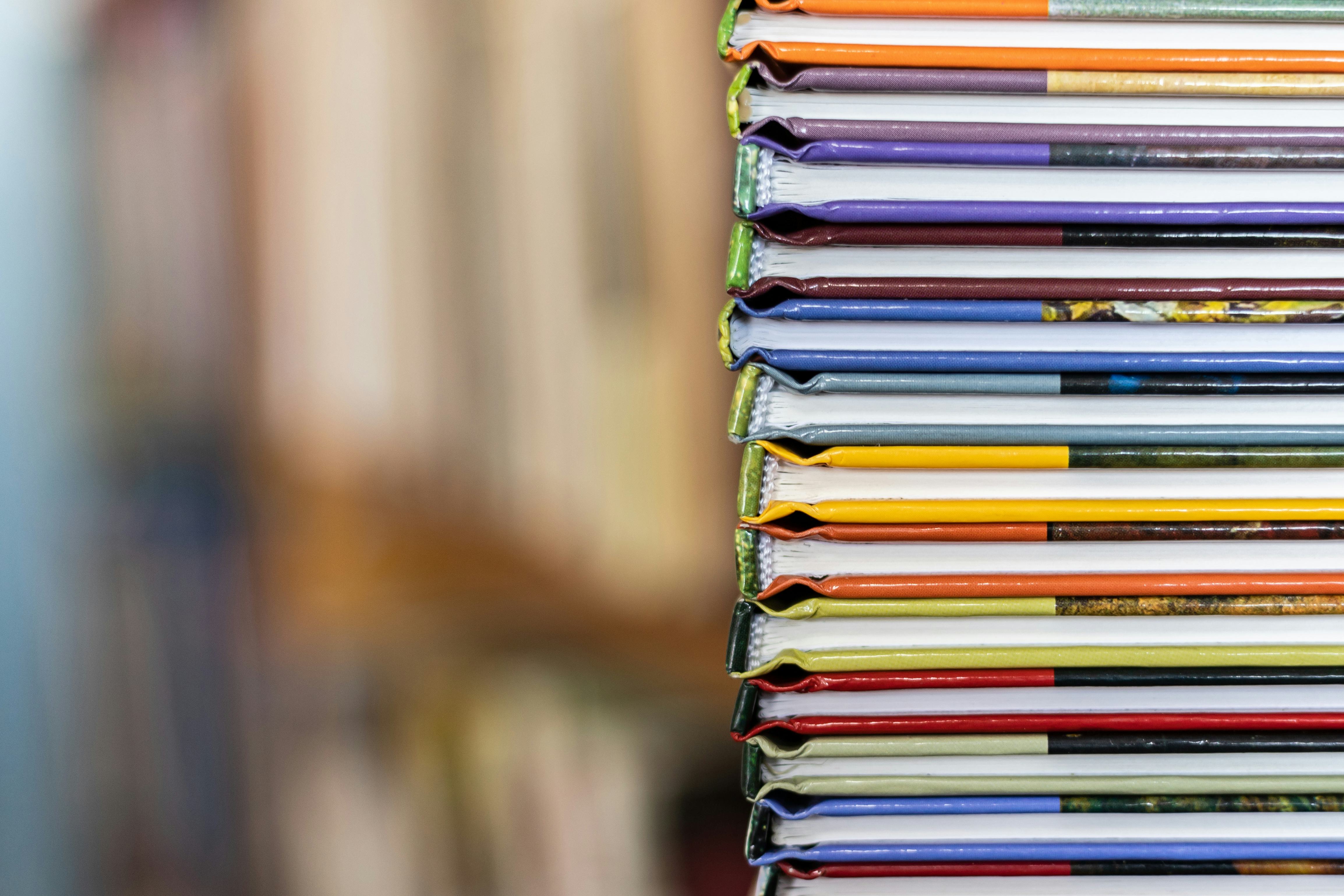 A stack of colorful books close up. A stack of multi-colored books close-up. View of the spine of th...