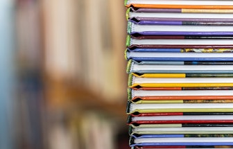A stack of colorful books close up. A stack of multi-colored books close-up. View of the spine of th...