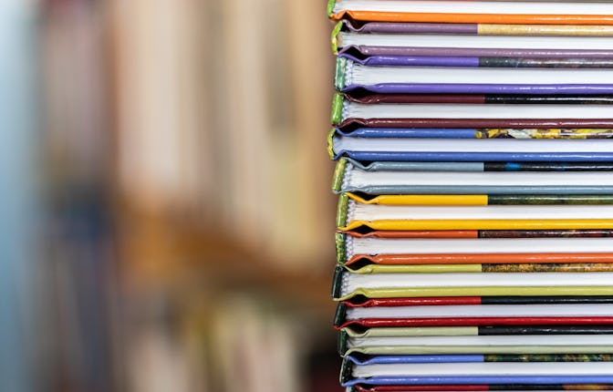 A stack of colorful books close up. A stack of multi-colored books close-up. View of the spine of th...