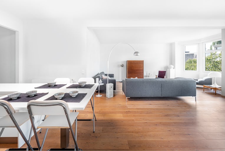 Minimal stylish bright kitchen connected to living room with wood floor, big sofas, retro furnitures...