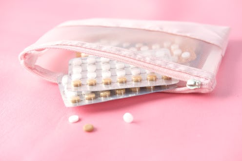 Birth control pills on a pink background