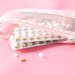 Birth control pills on a pink background