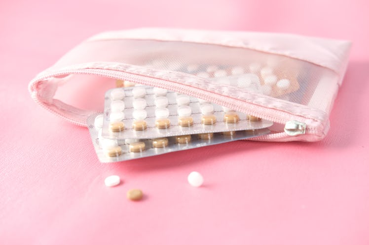 birth control pills on pink background, close up 