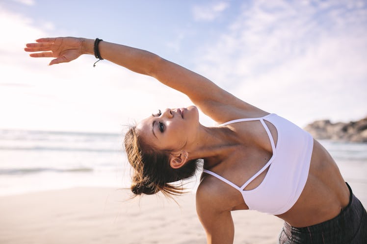 A woman doing a side bend as a summer yoga sequence.