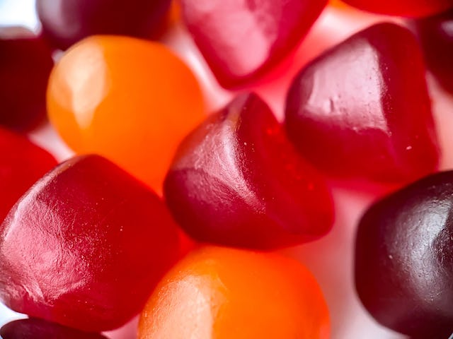 Close-up texture of red, orange and purple multivitamin gummies. Healthy lifestyle concept.