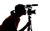 Silhouette of a female indie filmmaker, online content creator or casting director with a camera and...