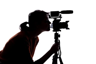 Silhouette of a female indie filmmaker, online content creator or casting director with a camera and...