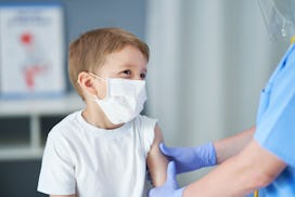 Portrait of adorable little boy being vaccinate at doctor's office.