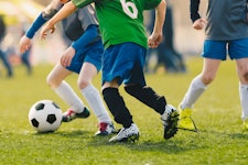 kids play soccer on a field