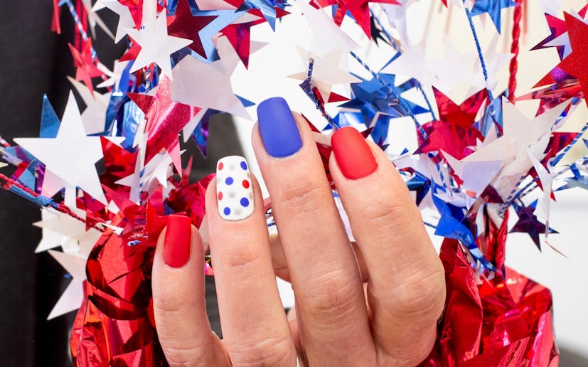 A red, white, and blue Fourth of July nail design with polka dots.