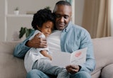 father and daughter reading a free printable Father's Day card 