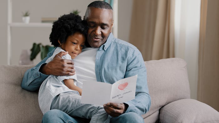 father and daughter reading a free printable Father's Day card