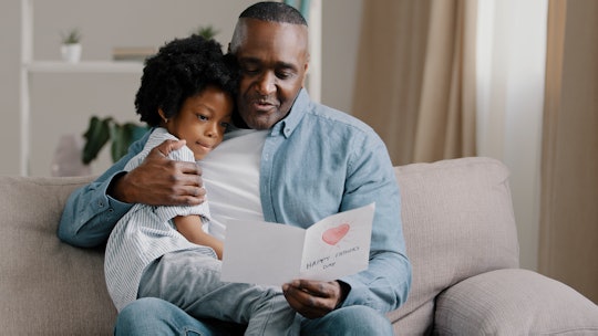 father and daughter reading a free printable Father's Day card 