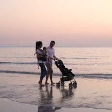  Parents are pushing the baby cart on the beach.