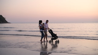  Parents are pushing the baby cart on the beach.