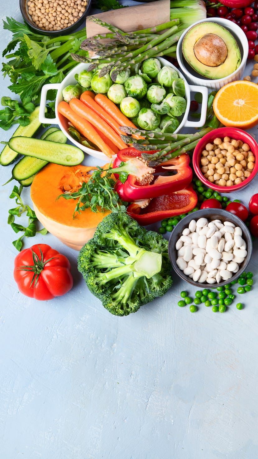 Raw and healthy plant-based foods, including red pepper, chickpeas, and carrots.