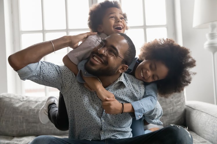 kids climbing on happy dad, father's day riddles will make the whole family laugh