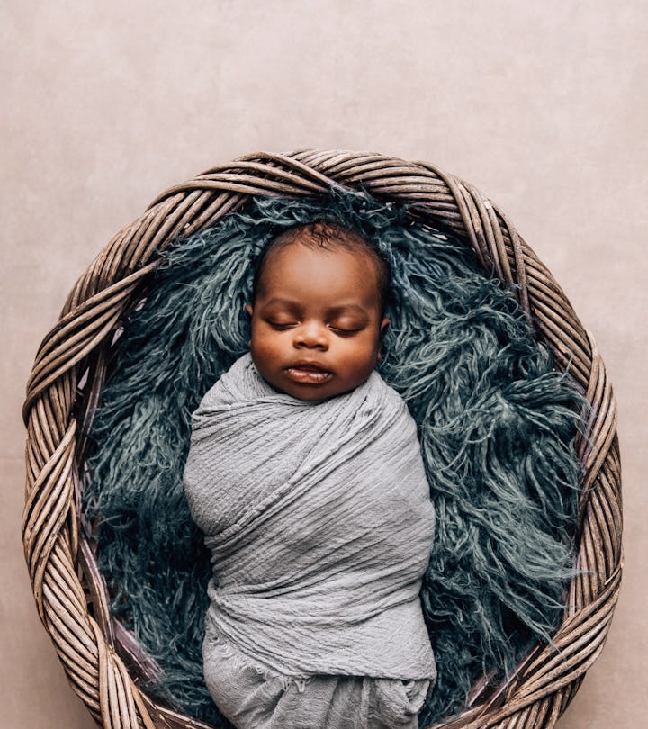 sleepy swaddled newborn baby boy laying on a blue rug. Can you breastfeed a swaddled baby??