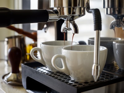 Preparing two cups of coffee on an espresso machine.