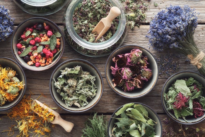 Bowls and jars of dry medicinal herbs. Healing herbs assortment, top view. Alternative medicine.