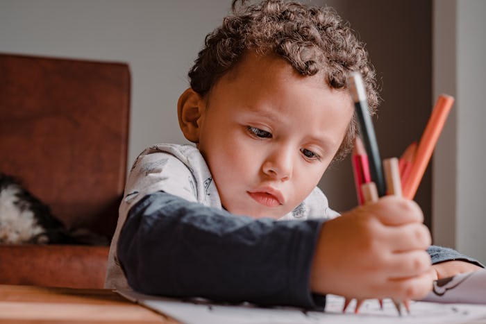 little boy coloring one of the Father's Day coloring pages in Spanish.