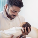 Closeup portrait of young asian Indian father holding his newborn baby with copy space. Healthcare a...