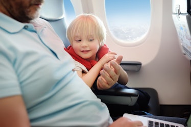 Portrait of little boy with his father during traveling by an airplane. Traveling with kids. Family ...