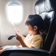 A child sits in the window seat of an airplane. New federal guidelines protect parents from having t...