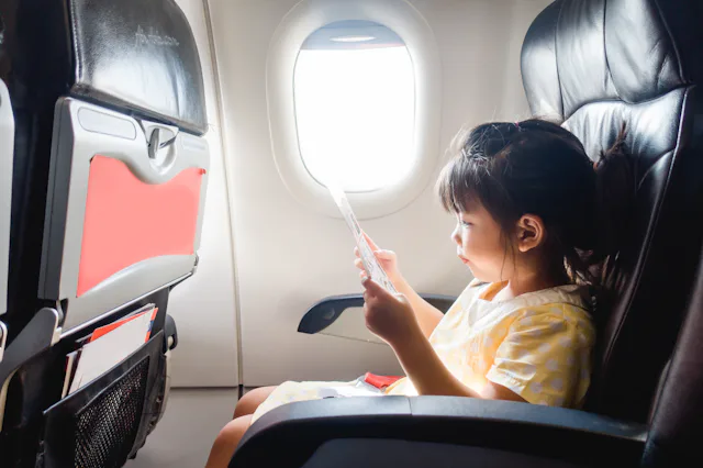 A child sits in the window seat of an airplane. New federal guidelines protect parents from having t...
