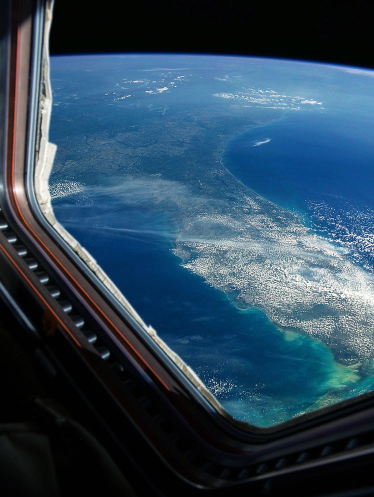 Spaceship flies near the amazing blue planet earth, view from the window. Travel and tourists in spa...
