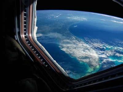 Spaceship flies near the amazing blue planet earth, view from the window. Travel and tourists in spa...