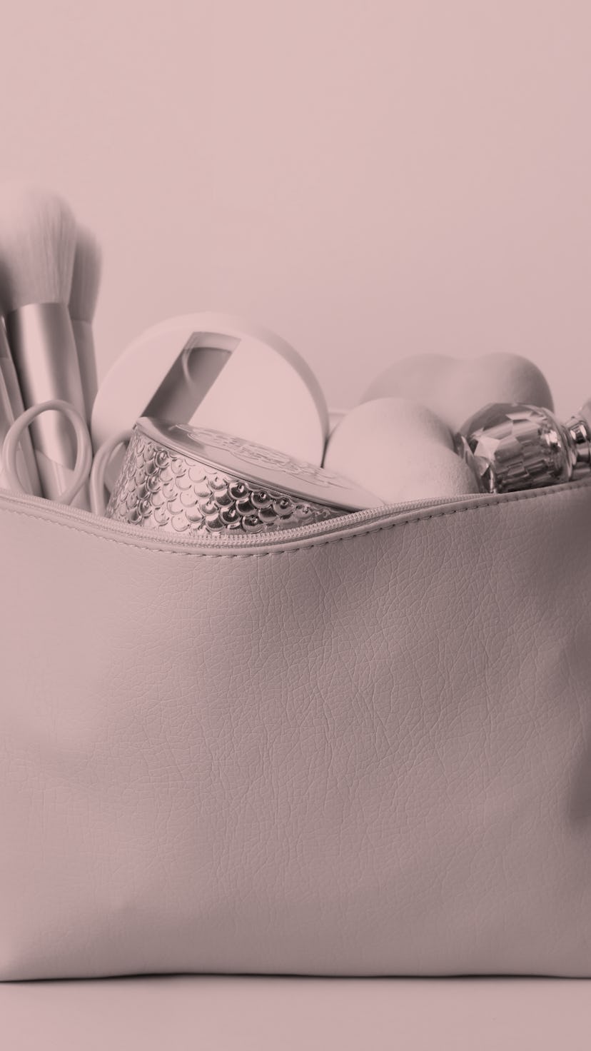 Cosmetic bag with makeup products and beauty accessories on yellow background