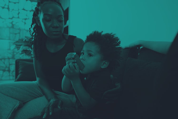 Worried mother looking at son using inhaler when having asthma attack at home