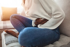 Young woman suffering from stomach cramps after sex in an article about why your stomach hurts after...