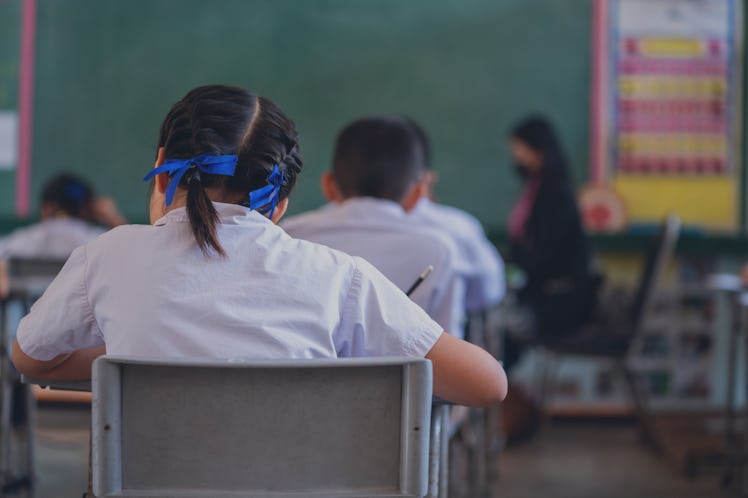 Close up of Writing test in exam with behind child asian students group concentrate in primary schoo...
