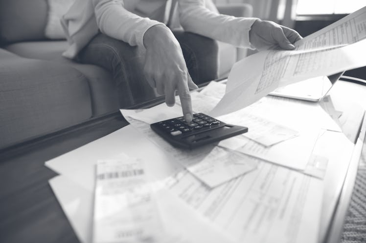 Close up busy woman using calculator, renter checking bills, planning budget, sitting at desk with f...