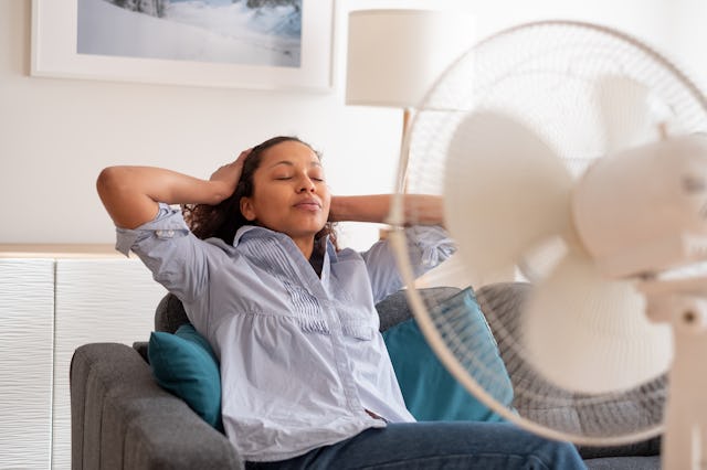 Black woman portrait cooling off at home during summer heat