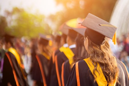 Rear view of the university graduates line up for degree award in university graduation ceremony. Th...