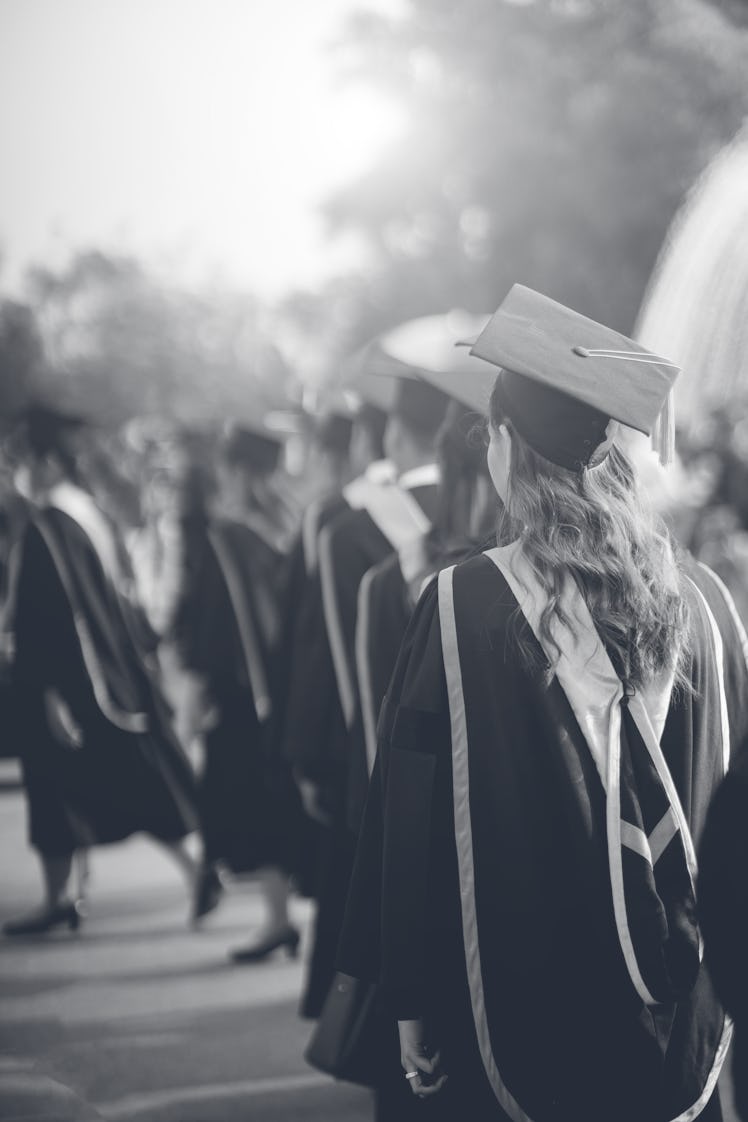 Rear view of the university graduates line up for degree award in university graduation ceremony. Th...