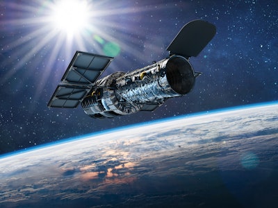 Hubble telescope on orbit of Earth. Space observatory. Telescope in outer space near surface of blue...