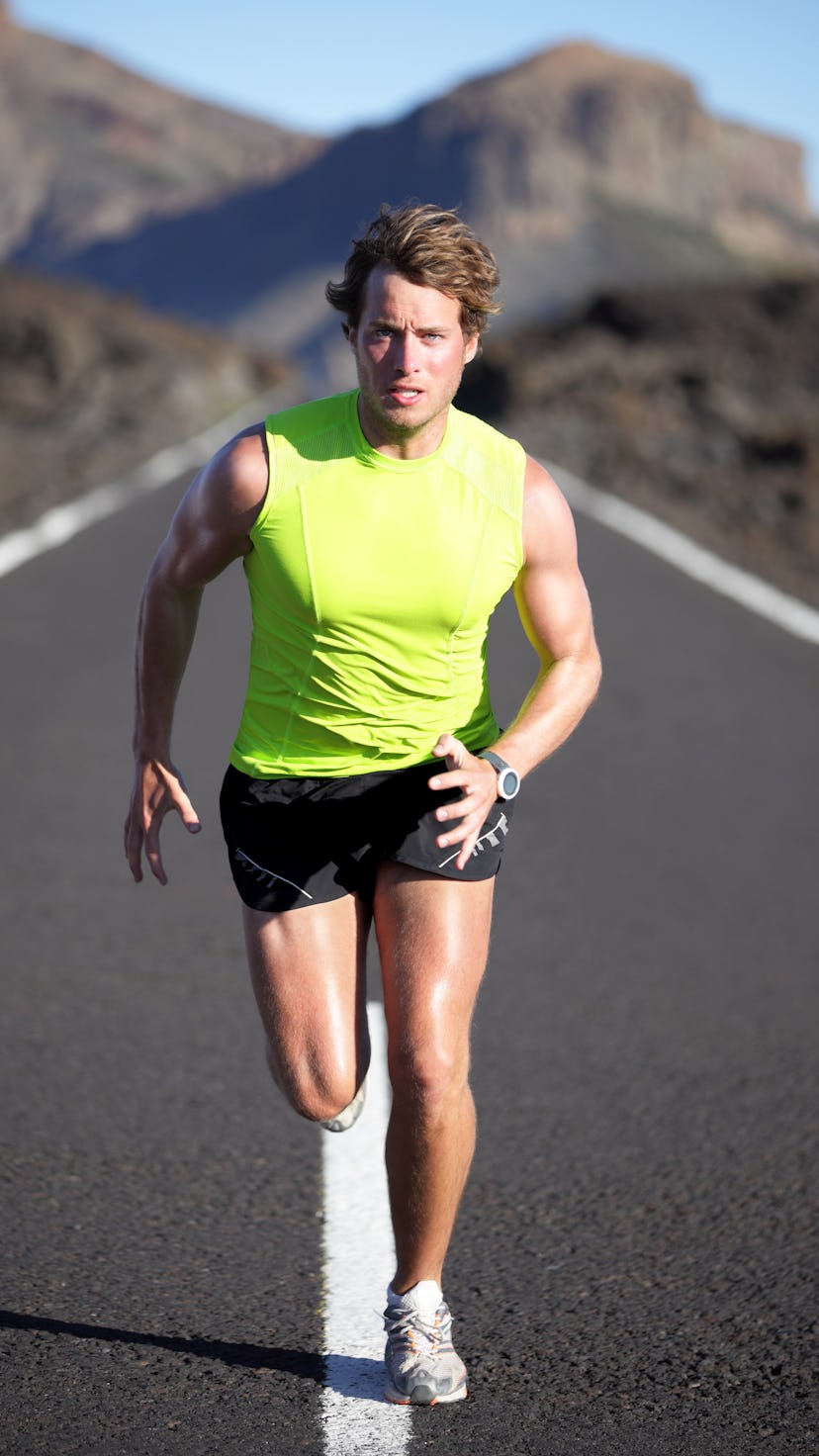 Running man athlete on road outdoors. Fit fitness runner man running and sweating in beautiful rough...