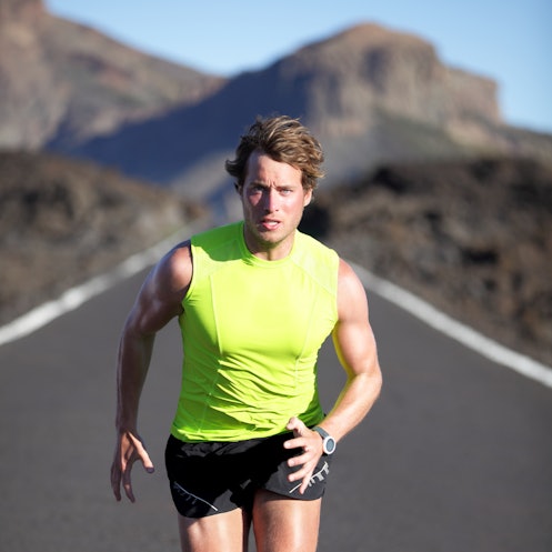 Running man athlete on road outdoors. Fit fitness runner man running and sweating in beautiful rough...